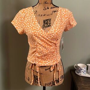 Outlaw orange crop  top with floral daisy pattern. Size medium. NWT.